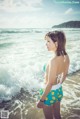 A woman in a bikini standing on the beach.