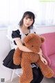 A woman sitting on a chair holding a teddy bear.