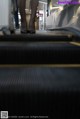 A person walking down an escalator in a shopping mall.