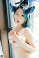 A woman in a white lingerie with blue hair and cat ears.