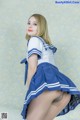 A woman in a blue and white uniform posing for a picture.