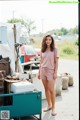 A woman standing in front of a pile of junk.