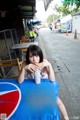 A woman sitting at a table with a drink in her hand.