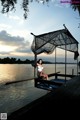 A woman sitting on a dock with a net over her head.