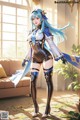 A woman with long blue hair standing in a living room.