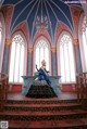 A woman in a blue and black dress standing on a staircase.