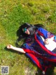 A woman laying on the ground in the grass.