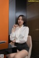 A woman sitting at a desk with a pen in her hand.