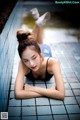 A woman laying on the ground next to a swimming pool.