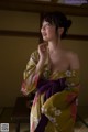 A woman in a yellow kimono standing in a room.