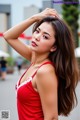 A woman in a red dress posing for a picture.